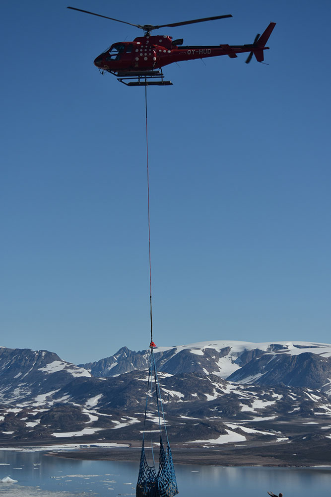 Fotografi af en helikopter som transporterer geologisk materiale